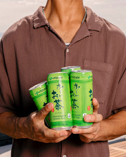 man holding Oi Ocha unsweetened canned green tea